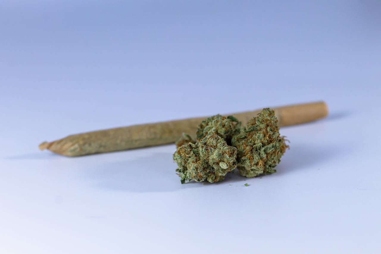 A close-up image of a cannabis joint and buds set against a neutral background, perfect for illustrating marijuana-related topics.